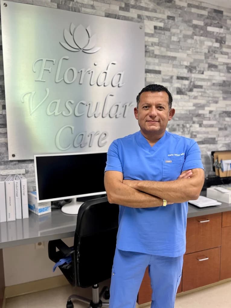 Dr. Hany Anton in scrubs, arms crossed, in front of the Florida Vascular Care sign at the Pompano Beach office.